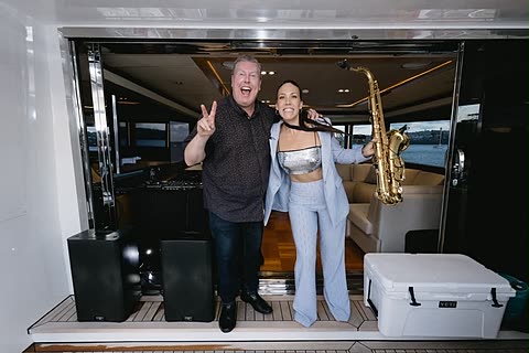 A DJ and a saxophonist posing together before an evening set.