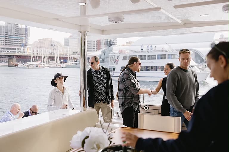 Corporate guests mingling on the deck of a charter boat at Darling Harbour.