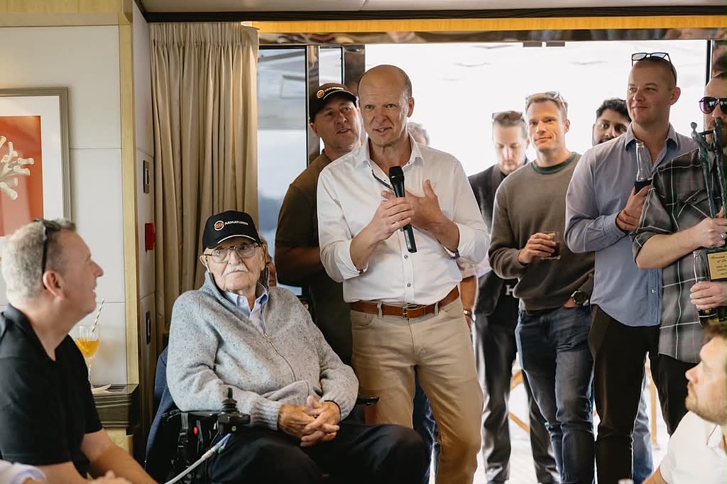 A speaker addressing an attentive group of guests during a milestone celebration.